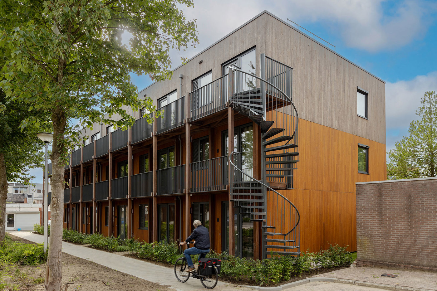 Duurzaam en circulair gebouwde woningen, persoon op de fiets voor de woningen